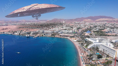 Alien ufo Saucers over Large Vacation City desert near sea,Aerial Red sea, Eilat city, Israel Drone view with visual effect Elements, summer 