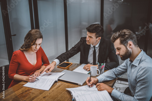 Lawyer helping a couple to fill legal papers