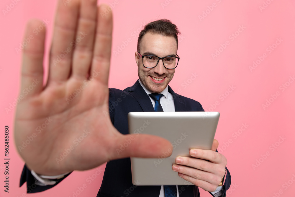 smiling young businessman in suit framing and holding tab smiling young businessman in suit framing and holding tab