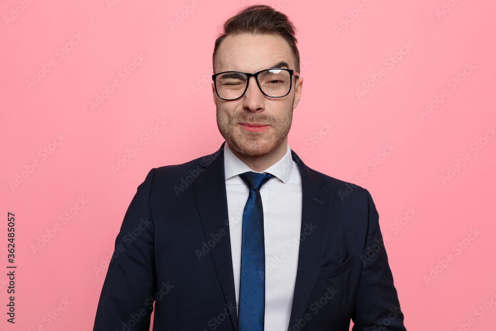 sexy young businessman in suit wearing glasses and winking sexy young businessman in suit wearing glasses and winking