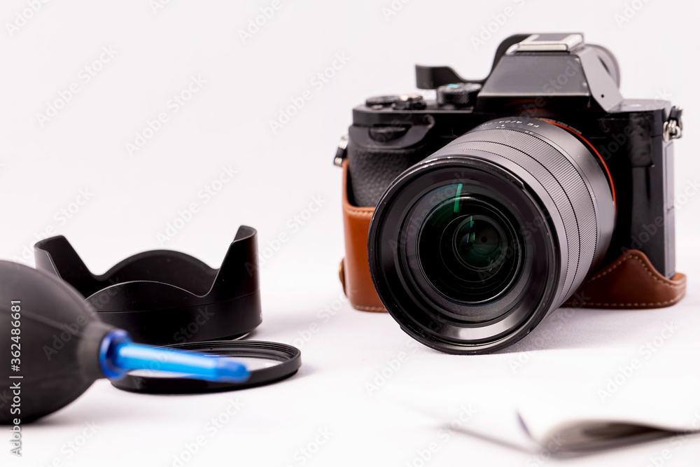 camera with lens and a pear for optics care on a white background.