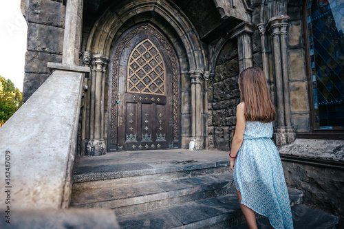A little girl child in a dress goes up the steps to the door of a beautiful fairy-tale castle, a dreamer © KseniaJoyg
