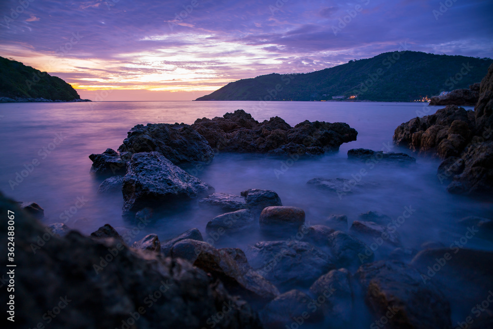 Long exposure image of Dramatic sky seascape with rocks in the foreground sunset or sunrise scenery background. Long exposure image of Dramatic sky seascape with rocks in the foreground sunset or sunrise scenery background.
