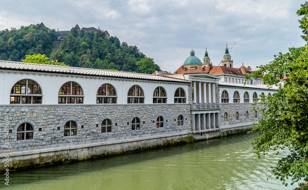 The river Ljubljanica in Ljubljana, Slovenia with traditional Slovenian architecture and Ljubljana Castle on the hill