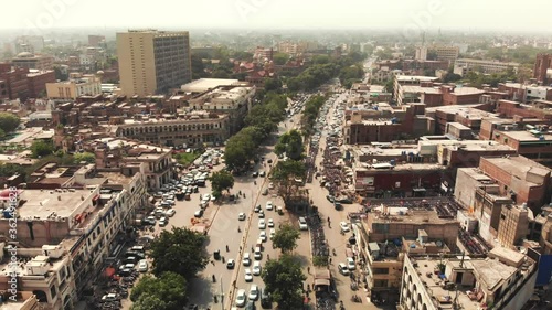 Descending aerial view of Lahore in Pakistan under a cloudy day, with its cityscape, markets, streets and cars, during a foggy day filled with polution.