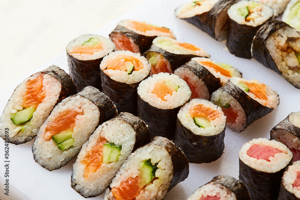Various kinds of sushi roll set served on cutting board. Japanese food Various kinds of sushi roll set served on cutting board. Japanese food