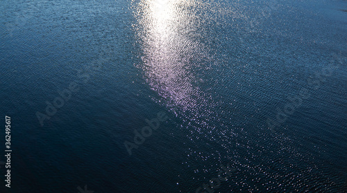Obraz na plátně Abstract texture background of bright sun rays reflecting on the waves in the water