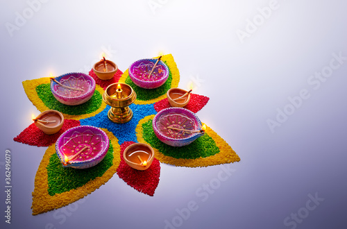 Konstfotografi Happy Diwali, diya lamps lit on colorful rangoli with copy space