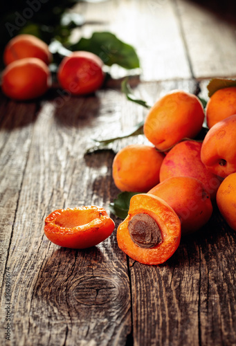 Fototapeta Naklejka Na Ścianę i Meble -  Fresh juicy apricots with leaves on a old wooden table.