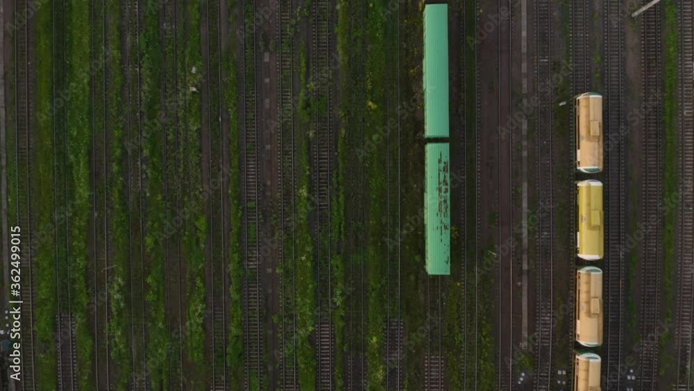 Railway rails view from the copter. Large sorting station. Yellow and green freight cars. Railway rails view from the copter. Large sorting station. Yellow and green freight cars.