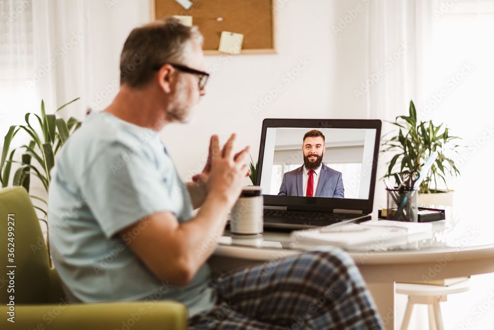Fototapeta premium Businessman chatting with his colleague. Working at home.