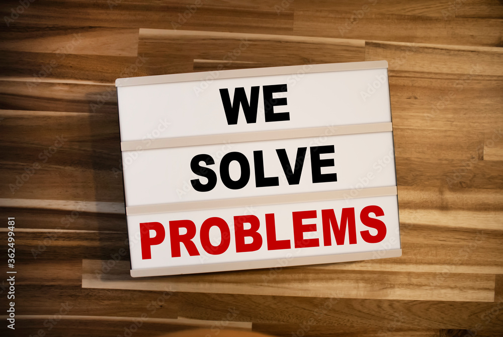 Light box or lightbox with message We Solve Problems on a wooden table background Light box or lightbox with message We Solve Problems on a wooden table background