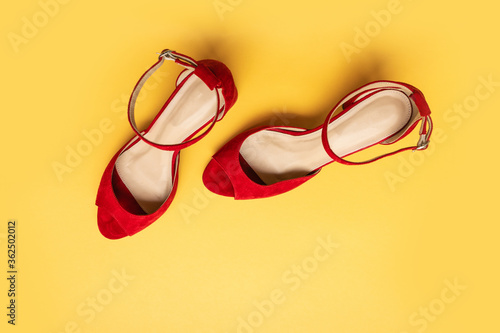 Red womens high heel shoes top view on bright yellow background with copy space. Beauty and fashion concept. Top view, flat lay