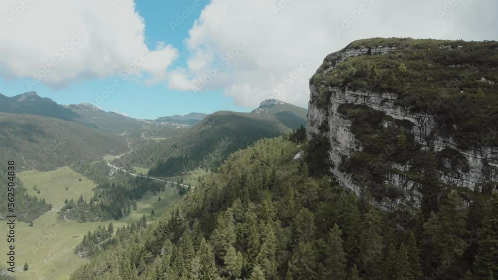 Italian moutains, nearby Asiago, Trentino - stony road around Tre Cime. Peak in the clouds and forest. Aerial shot. Beautiful sky and clouds behinds the moutains and valley. Italian moutains, nearby Asiago, Trentino - stony road around Tre Cime. Peak in the clouds and forest. Aerial shot. Beautiful sky and clouds behinds the moutains and valley.