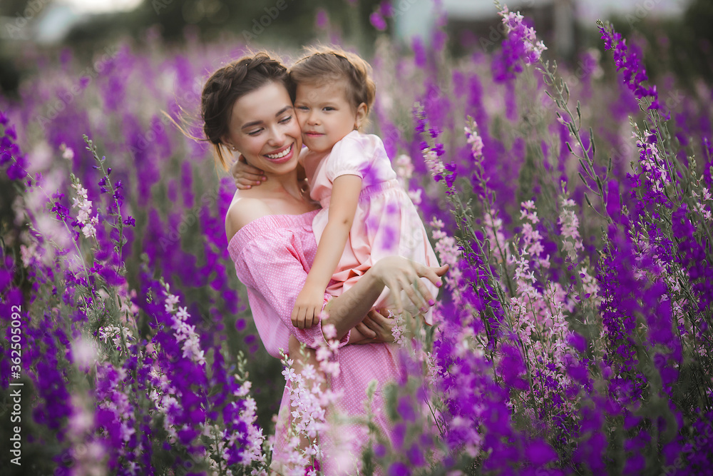 Pretty little girl and her mother with flowers. Family outdoors Pretty little girl and her mother with flowers. Family outdoors