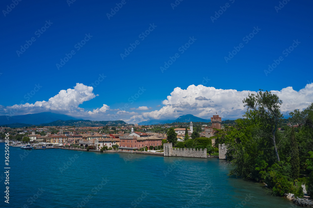 Lazise, Lake Garda, Italy. Aerial view of the historic city of Lazise, in the background cumulus clouds on a blue sky