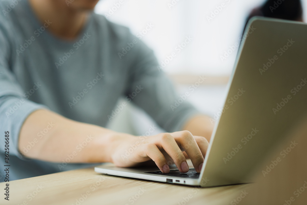 A man in casual outfit using and typing laptop for working at home in the morning day A man in casual outfit using and typing laptop for working at home in the morning day