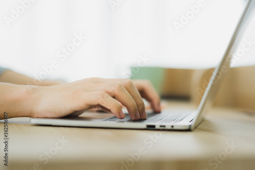 Close up a man using and typing laptop for working at home in the morning day