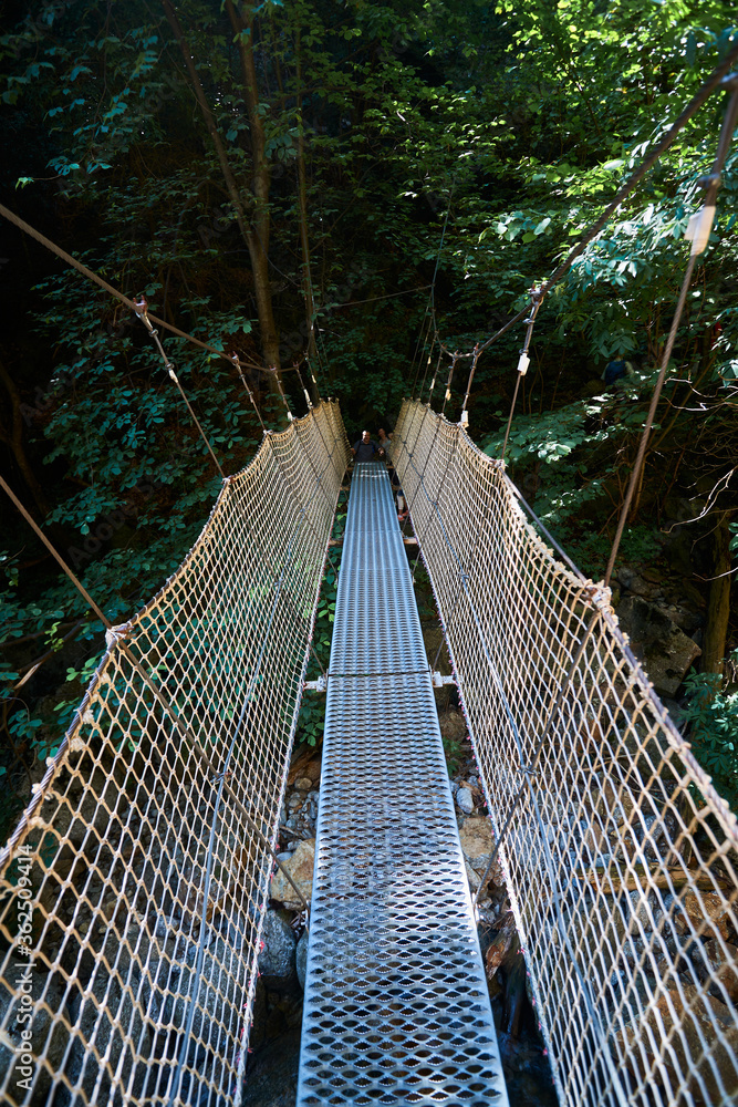 Suspension bridge with ropes crossing a river