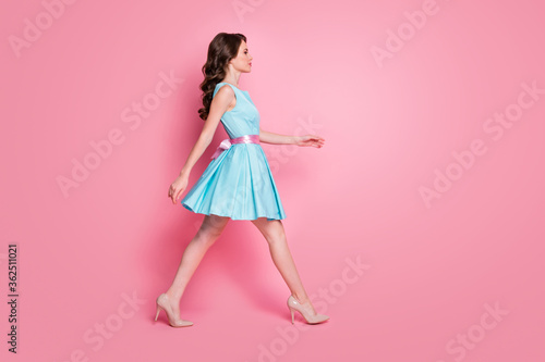 Full length profile photo of wavy charming lady walking moving festive event prom party graduating school college wear blue mini dress stilettos isolated pink color background