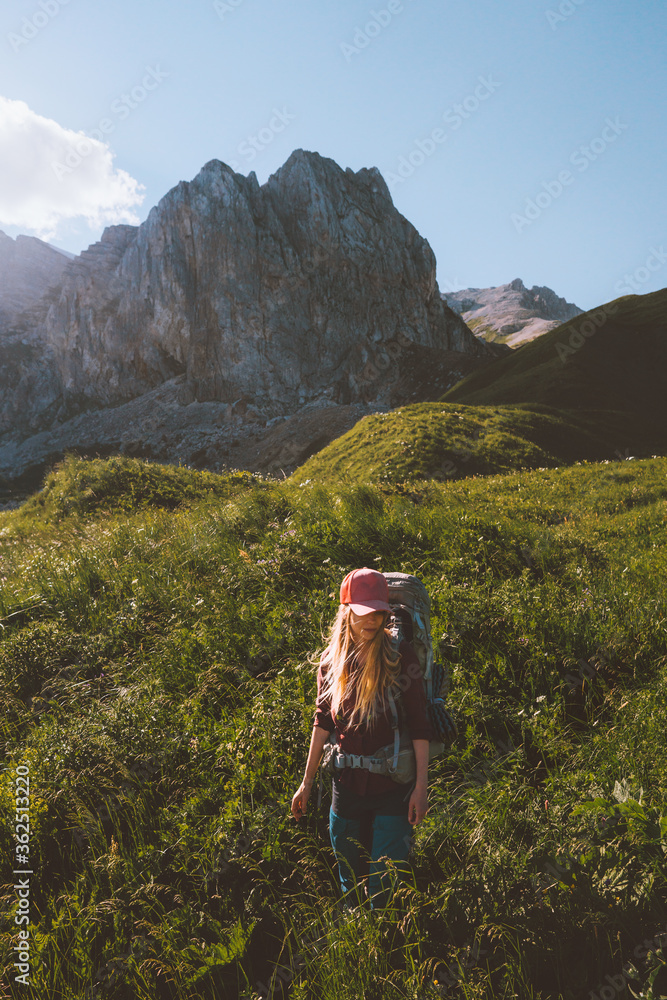 Young woman hiking in mountains with backpack travel eco tourism outdoor adventure vacations active healthy lifestyle summer green valley and rocky mountains view