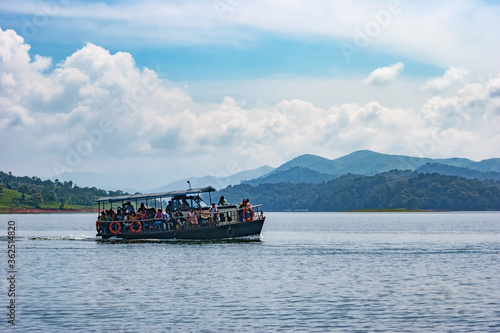 A picturesque view of a tourist boat on a lake surrounded by rai