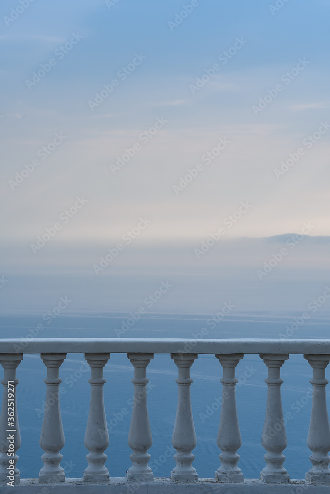 Early morning panoramic sea view from a white balcony with columns