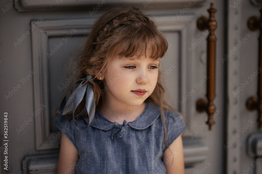 girl in a gray dress stands at the gray wooden door in summer
girl in a gray dress stands at the gray wooden door in summer