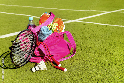 Bag with sports equipment on the sports courts background in the sunny day.