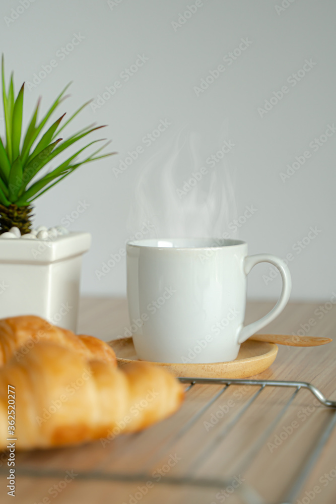 Fototapeta premium Two fresh croissants and cup of coffee on dark stone table