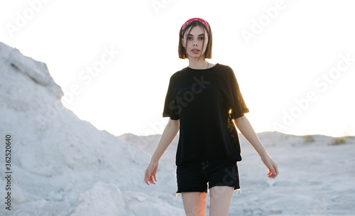Sexy woman or girl wearing black blank t-shirt with space for your logo, mock up or design outdoors