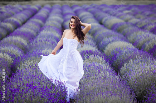 Young woman running in the lavender field. Beautiful woman on summer floral background