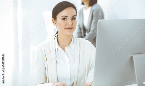 Casual dressed business woman working with computer in office. Lawyer or accountant at work