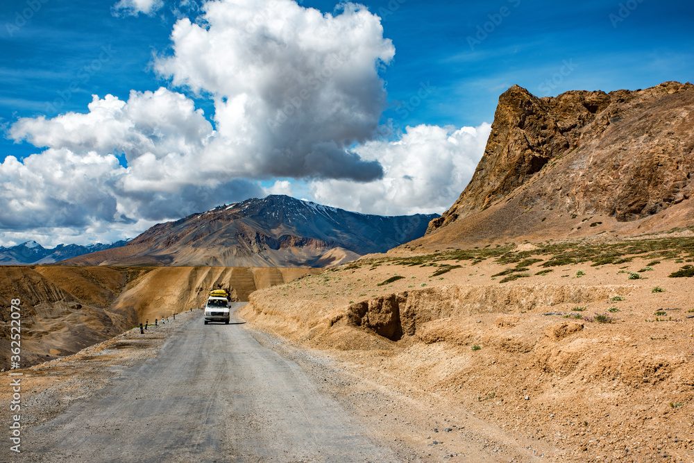 View of arid landscape of highway road for travel with big mountain and blue sky as background, Leh Ladakh - India View of arid landscape of highway road for travel with big mountain and blue sky as background, Leh Ladakh - India