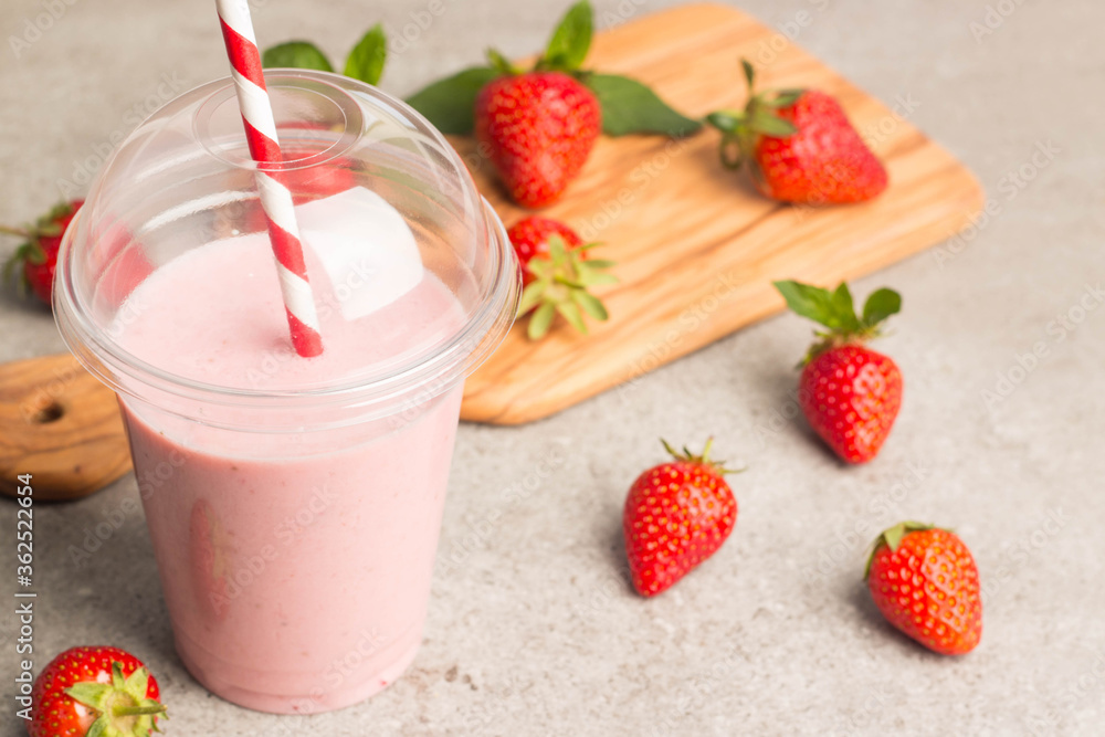 Glass of fresh strawberry milkshake, smoothie and fresh strawberries on pink, white and wooden background. Healthy food and drink concept. Glass of fresh strawberry milkshake, smoothie and fresh strawberries on pink, white and wooden background. Healthy food and drink concept.