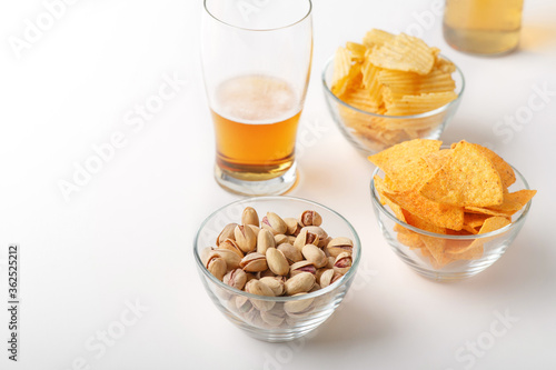 Beer snack. Bright lager in glass, pistachios, nachos and chips
