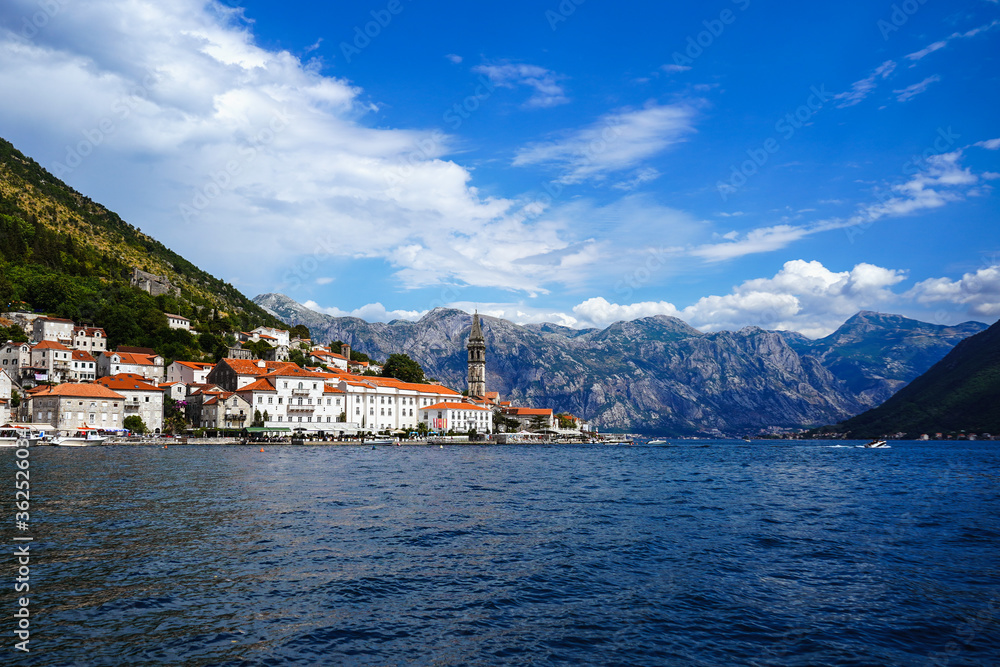 View of the mountain lake, mountains, pleasure yachts. An island in the middle of the lake. The famous fjord-like bay, on the rocky shores of which Kotor and Perast are located. Boko Kotor bay, cove.