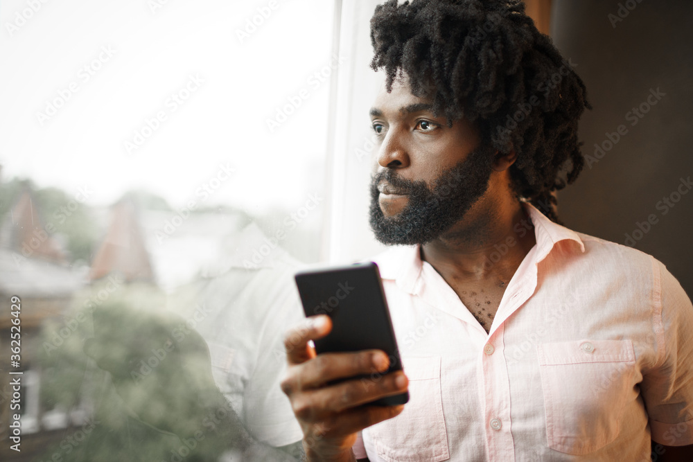 Bearded young african american man looking at his smartphone Bearded young african american man looking at his smartphone