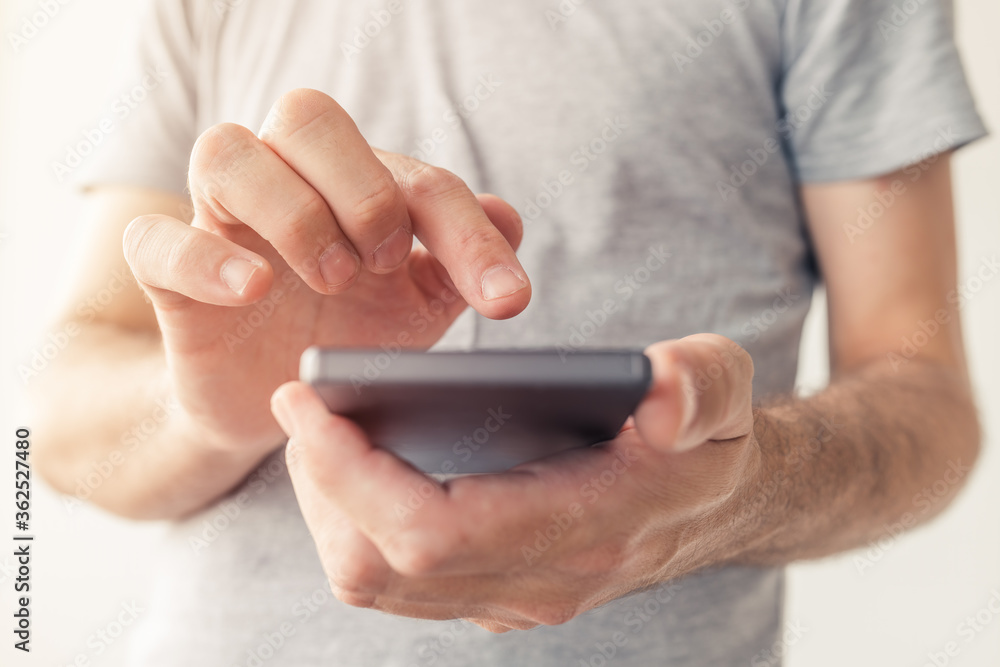 Close up of male hands typing text message on smartphone Close up of male hands typing text message on smartphone