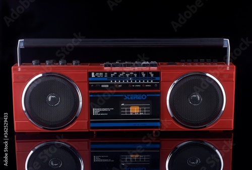 Vintage red boom box on black background with reflection
