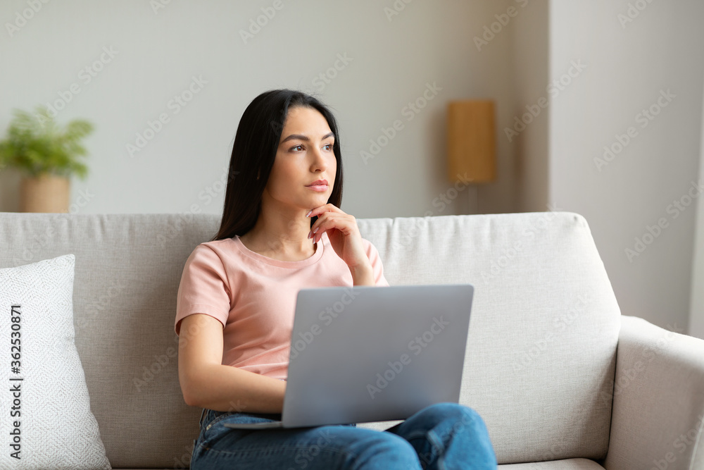Pensive Girl At Laptop Thinking Sitting On Couch At Home Pensive Girl At Laptop Thinking Sitting On Couch At Home