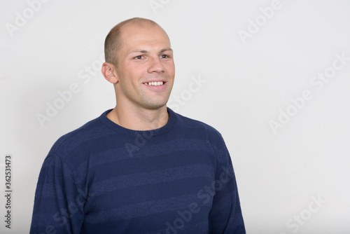 Portrait of happy young handsome bald man thinking © Ranta Images