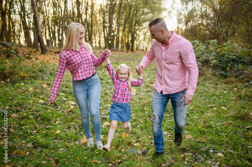 Father, daughter and mother walking outdoors. Happy family. © wolfhound911