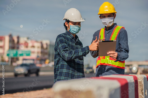 Asian man Engineer using tablet technology work on site construction road inspection work professional focus on tablet