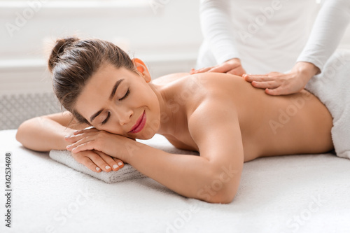 Relaxed woman getting healing body massage at spa