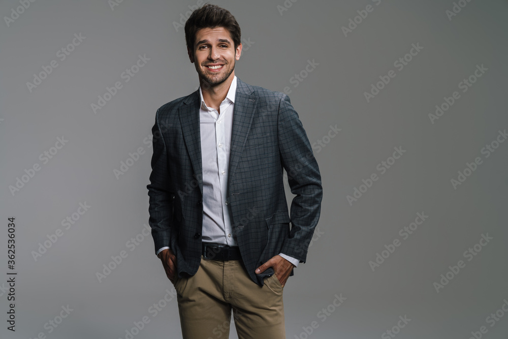 Fototapeta premium Photo of pleased businessman in jacket posing and smiling at camera