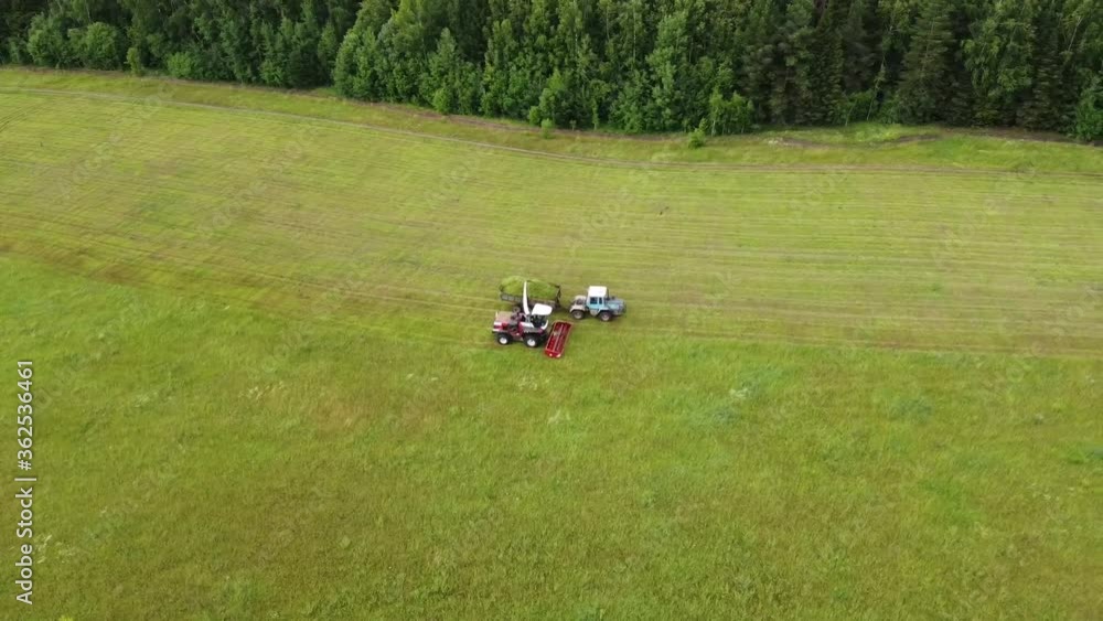 Aerial photography. Wide and close-up shots of a harvester cutting green grass. The concept of sustainable biofuels and organic food. Aerial photography. Wide and close-up shots of a harvester cutting green grass. The concept of sustainable biofuels and organic food.