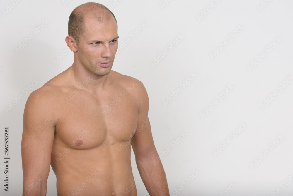 Young handsome muscular bald man thinking shirtless