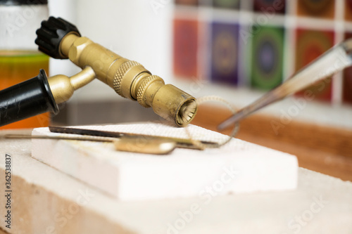 Goldsmiths tools on the jewelry workplace. Tools over rustic wooden background.