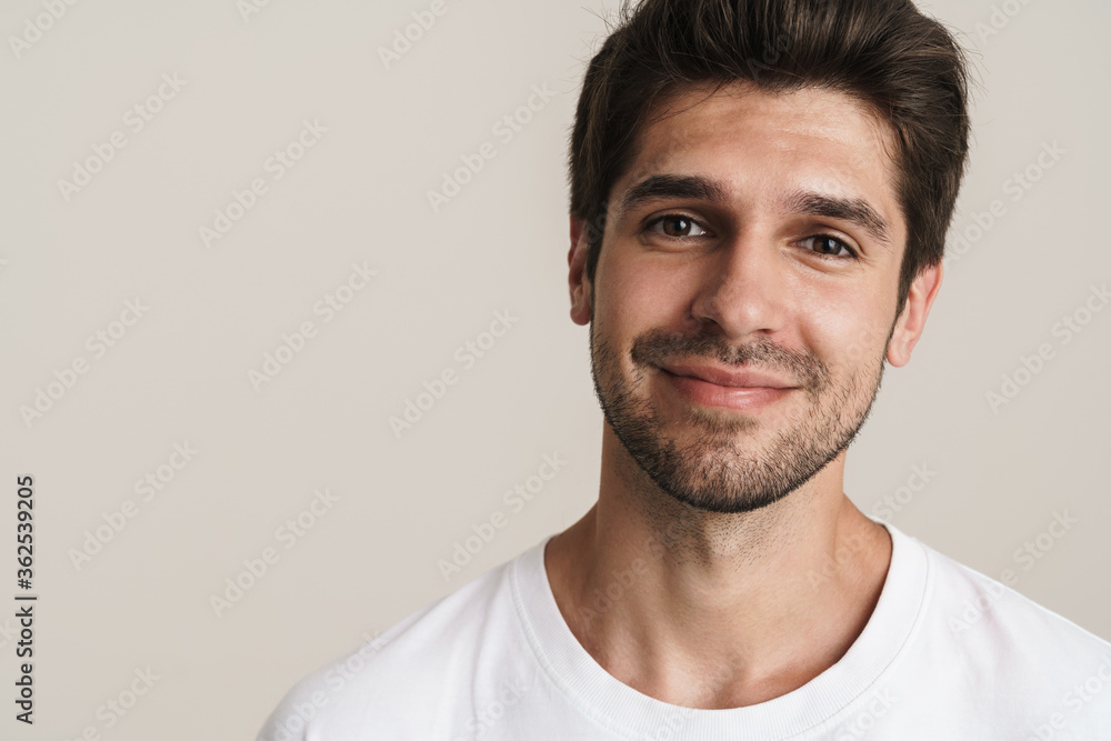 Fototapeta premium Portrait of joyful young man smiling and looking at camera